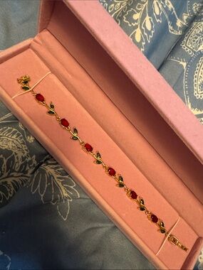 Gold Bracelet with Red Stones and Green Leaf Accents